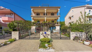 Un immeuble résidentiel à plusieurs étages, doté d’une entrée sécurisée, d’un jardin central et de balcons.
