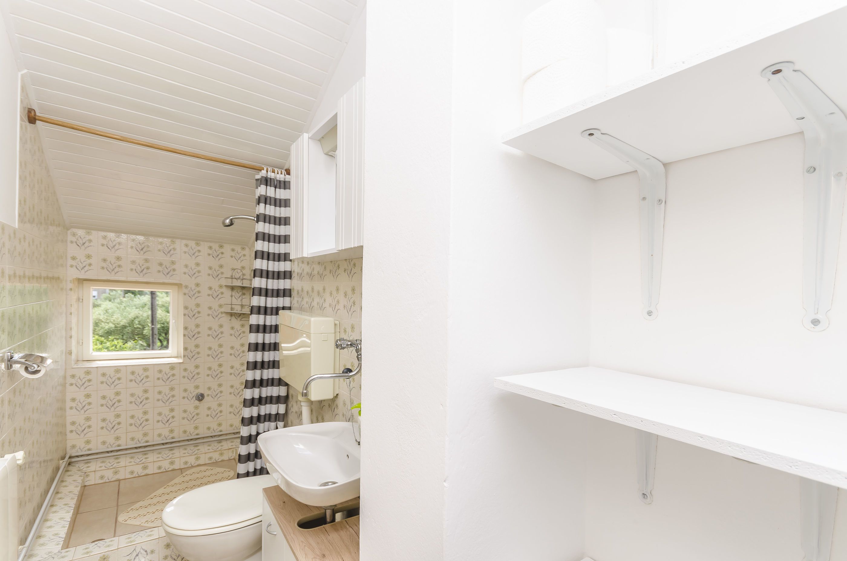 Ein Badezimmer mit Toilette, Waschbecken und Duschbereich.
