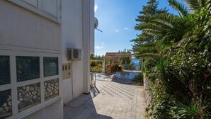 Ένα κτίριο με μια πλακόστρωτη αυλή, μια πισίνα και καταπράσινο περιβάλλοντα χώρο.
