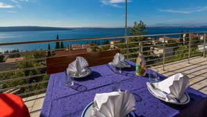 A table set for two with a view of a lake and mountains. - Apartments Dubravka (Crikvenica)