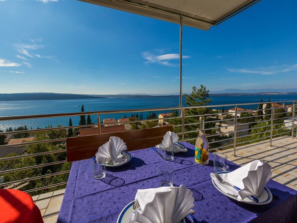 A table set for two with a view of a lake and mountains.