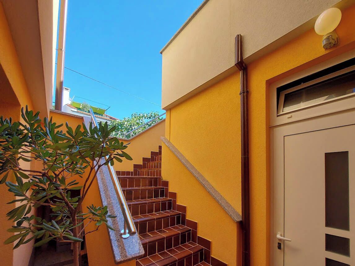 Una scala con corrimano che porta a una porta con una finestra.