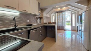 Una cocina moderna con una isla central, electrodomésticos de acero inoxidable y vistas al área exterior.