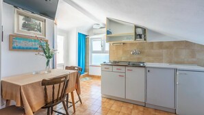 Une cuisine compacte comprenant un coin repas, un évier intégré et une machine à café.