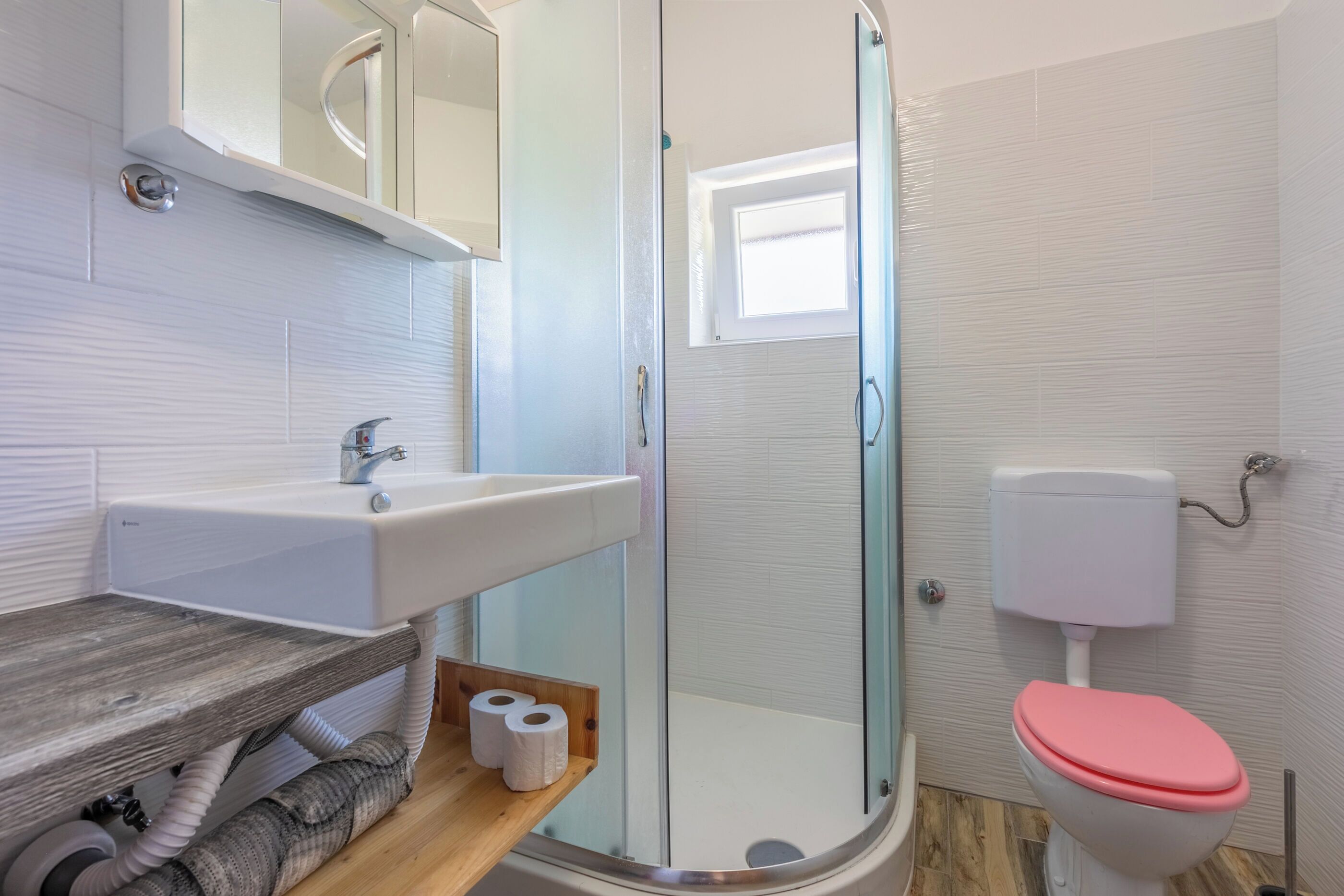 A bathroom with a shower, toilet, and sink.