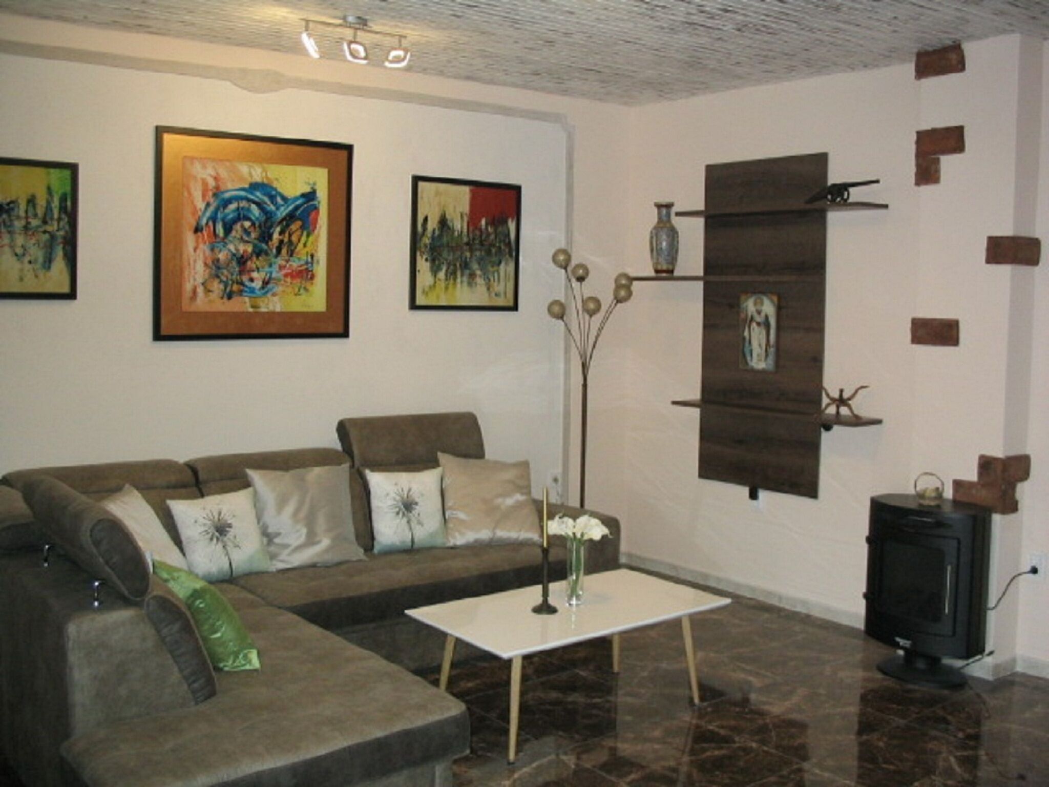 A living room with a sofa, a coffee table, and artwork on the walls.