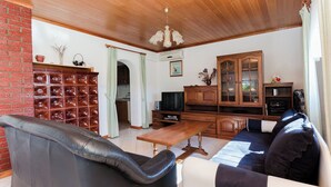 A living room with a sofa, a coffee table, a television, a cabinet, and a fireplace. - Apartments Biserka (Barbat)