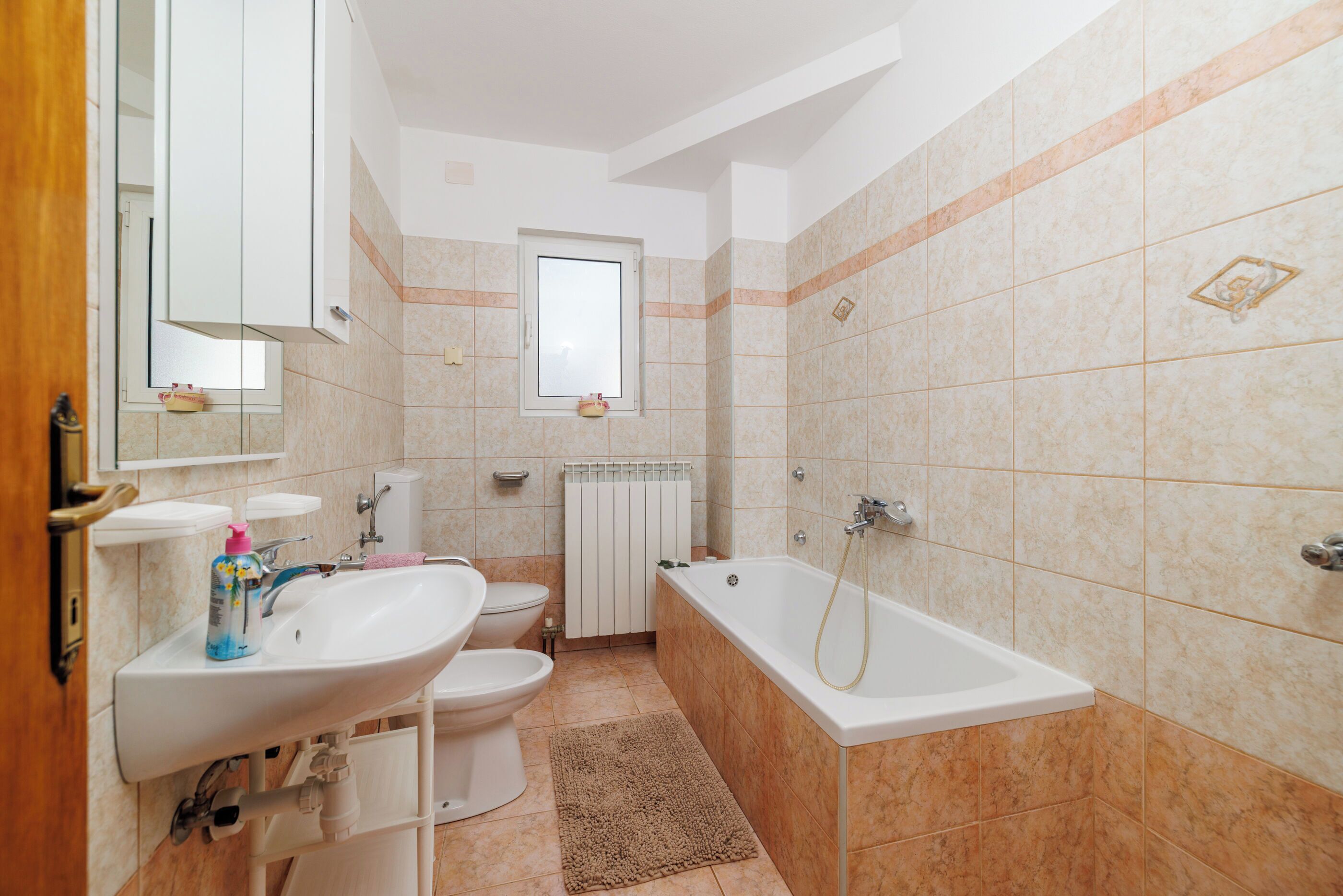 Ein Badezimmer mit Waschbecken, Toilette und Badewanne.