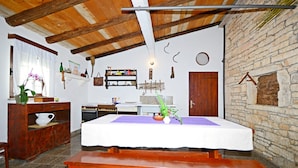 A rustic room with a wooden table, benches, and a stone wall. - Apartment Srblin (Zminj)