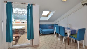 Una habitación con comedor, sofá y tragaluz.