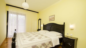 Una camera da letto con un letto, un comodino, uno specchio e una lampada a parete.