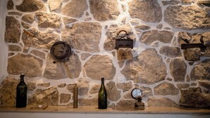 A stone wall with various kitchen utensils and bottles. - House Predrag (Supetarska Draga)