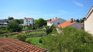 A residential area with houses, a stone wall, and a garden. - Apartments Dragica (Stinjan)