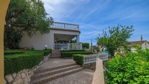A house with a stone staircase leading to a white balcony with a railing. - Apartments Ljubica (Kampor)