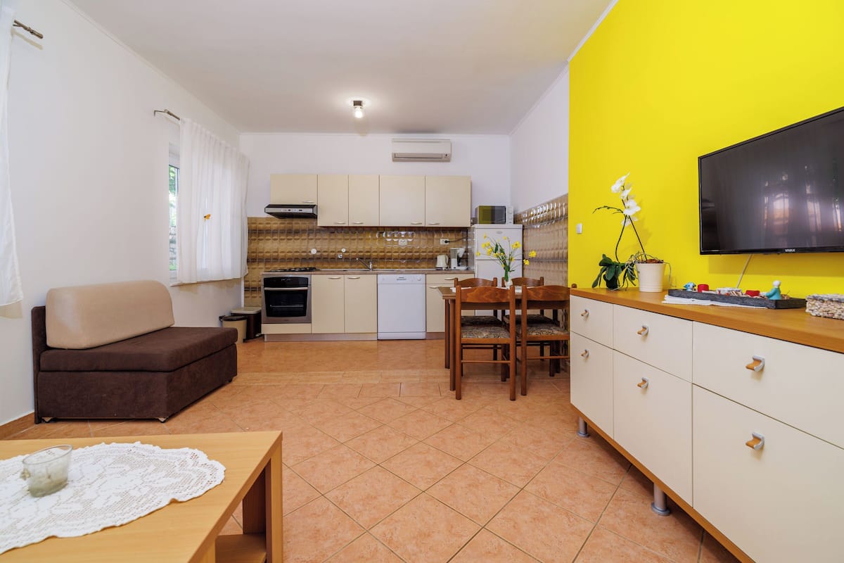 A compact living space with a kitchenette, a dining area, and a seating area.