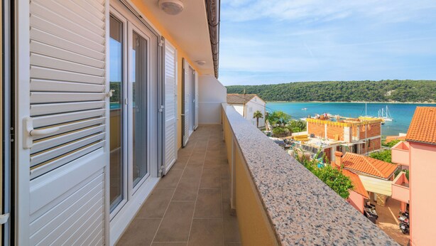 A balcony with a view of a coastal area, including a body of water and a bridge. - Apartments Ljubica (Kampor)