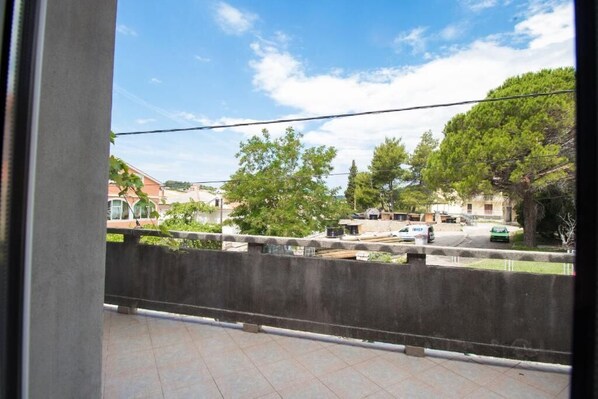 A balcony with a view of a residential area, including houses and trees.