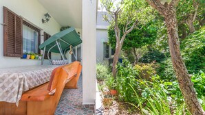 A wooden bench with a table, a potted plant, and a wall-mounted lamp. - Apartment Anica (Omis)