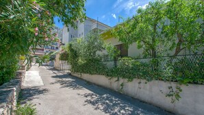 A narrow street lined with trees and a building with balconies. - Apartment Anica (Omis)