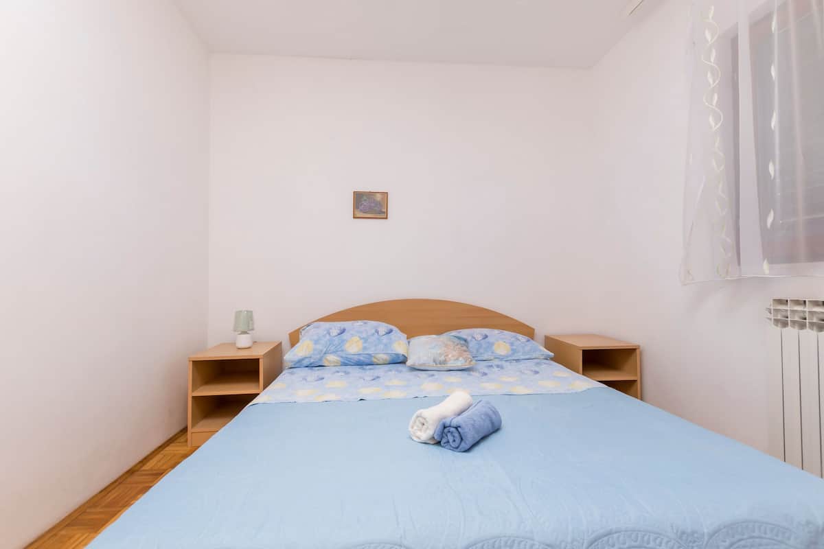 Ein Schlafzimmer mit einem Einzelbett, einem Nachttisch, einem kleinen Tisch und einer Heizung.