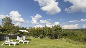A grassy outdoor area with white lounge chairs and a white umbrella. - House Dean (Labin)