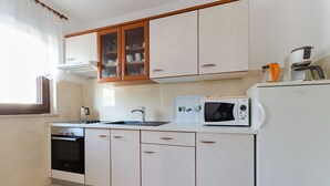 A kitchen with a microwave, oven, sink, and cabinets. - Apartment Marija (Porec)