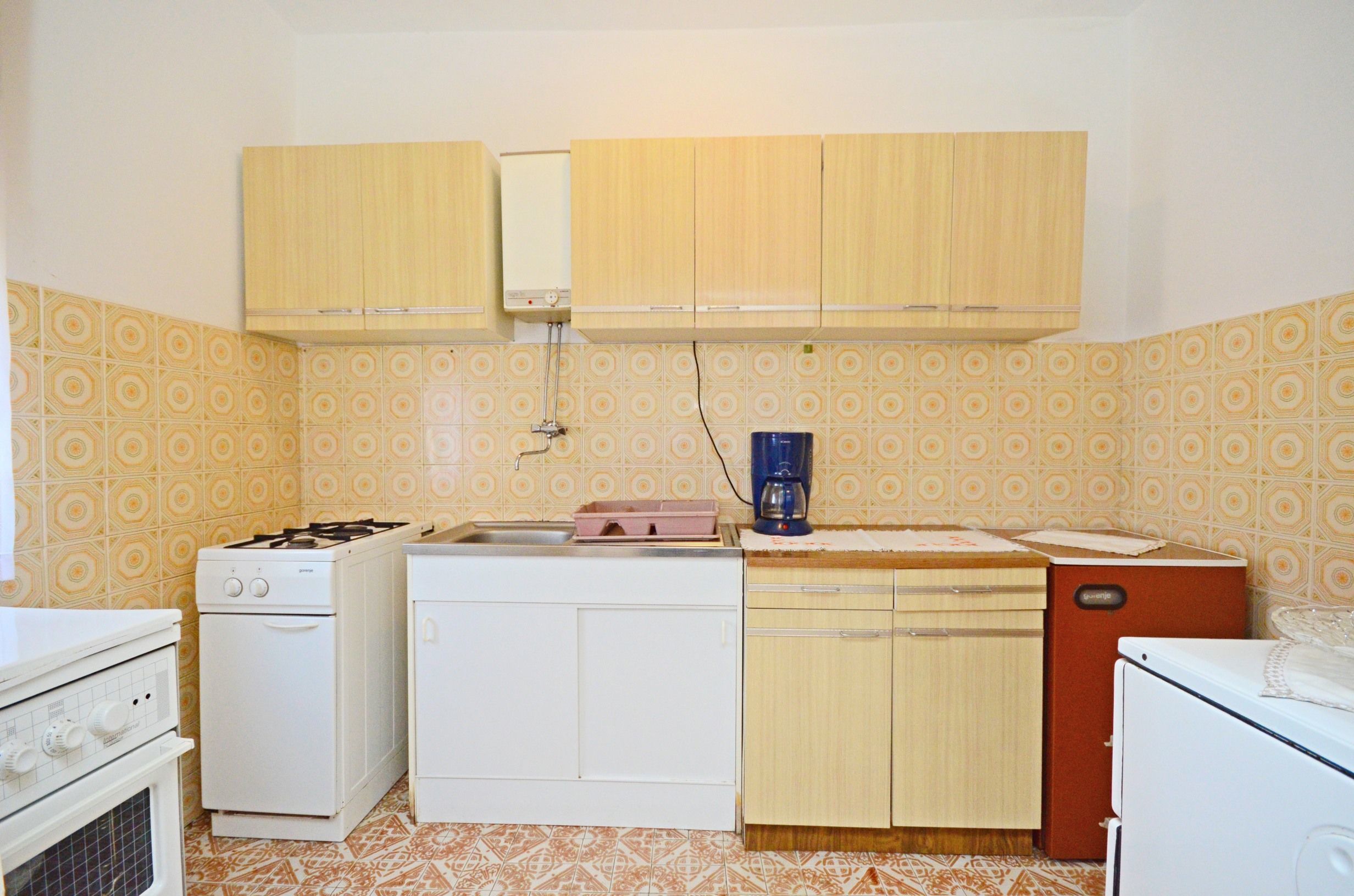 Cocina compacta con electrodomésticos básicos, incluyendo estufa, horno y lavavajillas.
