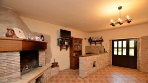 Una chimenea de piedra con un televisor encima, un mueble de madera y una pared de piedra.