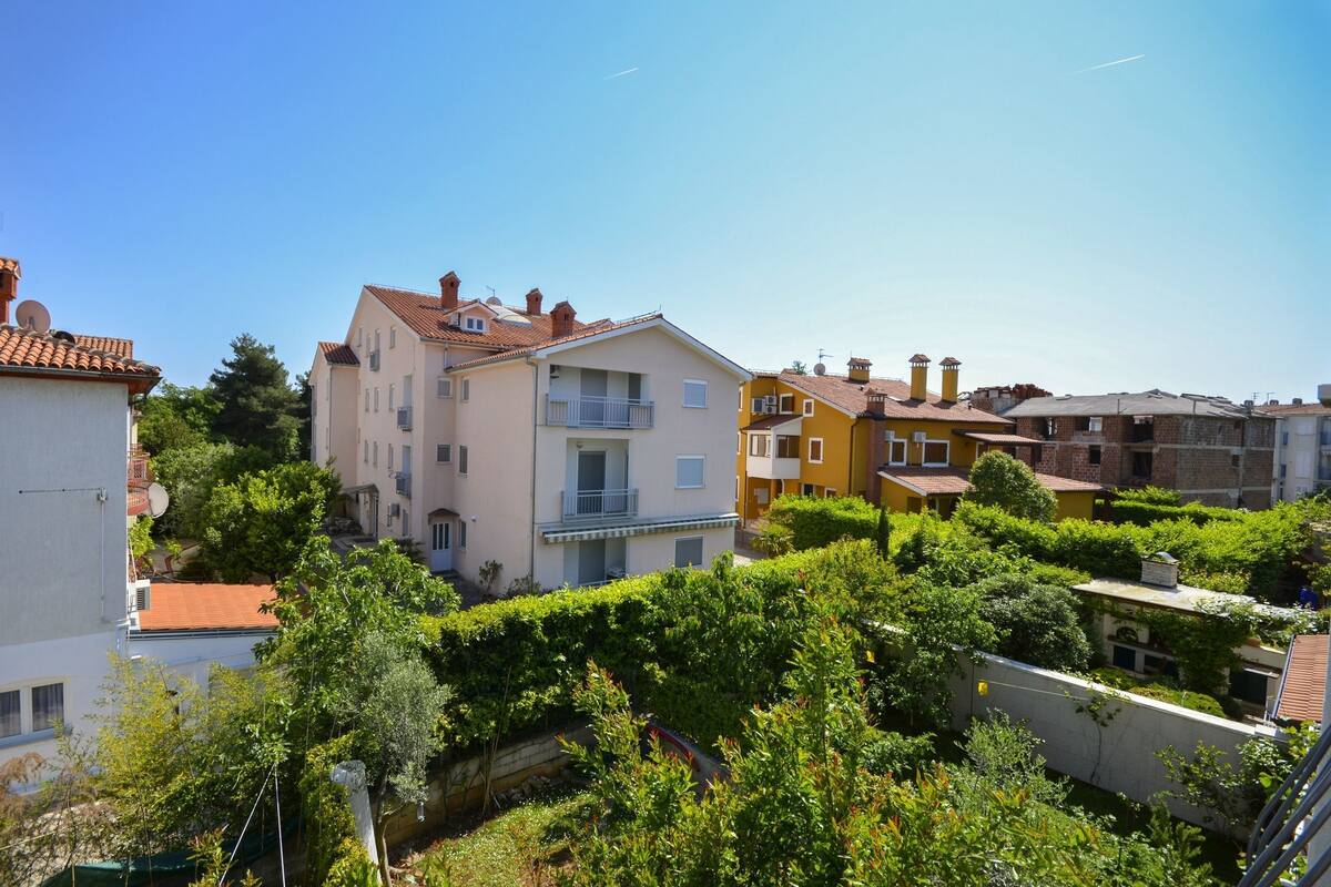 Un quartier résidentiel composé d’immeubles à plusieurs étages, dont certains sont dotés de balcons, et entouré de verdure.