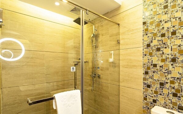 Ein modernes Badezimmer mit Duschkabine aus Glas, einem Handtuchhalter und einer Wand mit Mosaikfliesen.