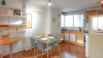 Una cocina moderna con armarios de madera, horno empotrado y ventana con persianas.