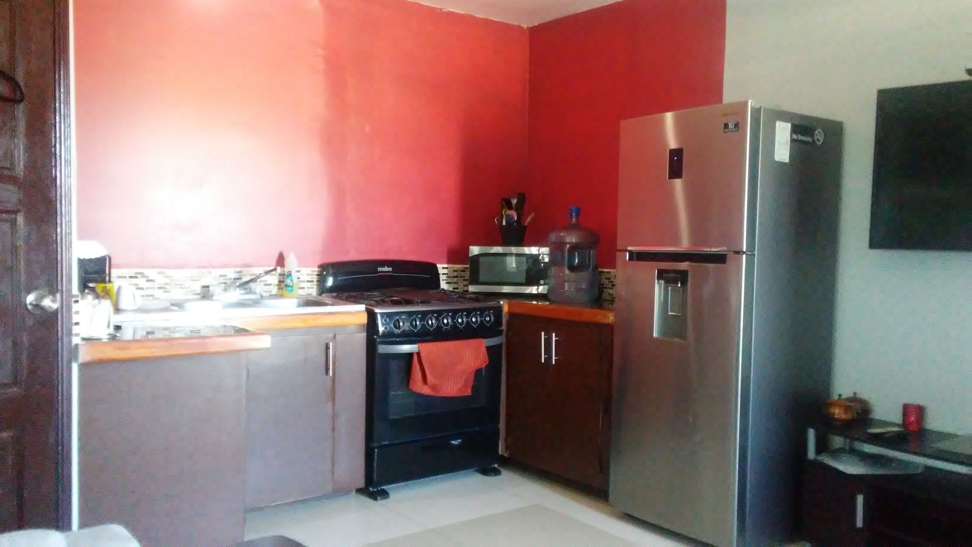 Una cocina compacta equipada con estufa, horno, microondas y refrigerador.