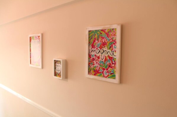 Una pared con tres obras de arte enmarcadas.