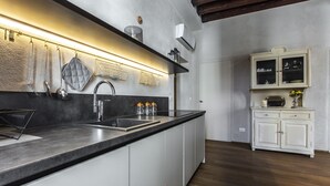 Une cuisine moderne dotée d’un îlot central, d’appareils électroménagers en acier inoxydable et de meubles de cuisine blancs.