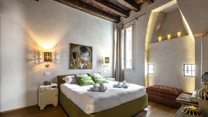 Une chambre avec un grand lit, des lampes de chevet, un tableau et une fenêtre.