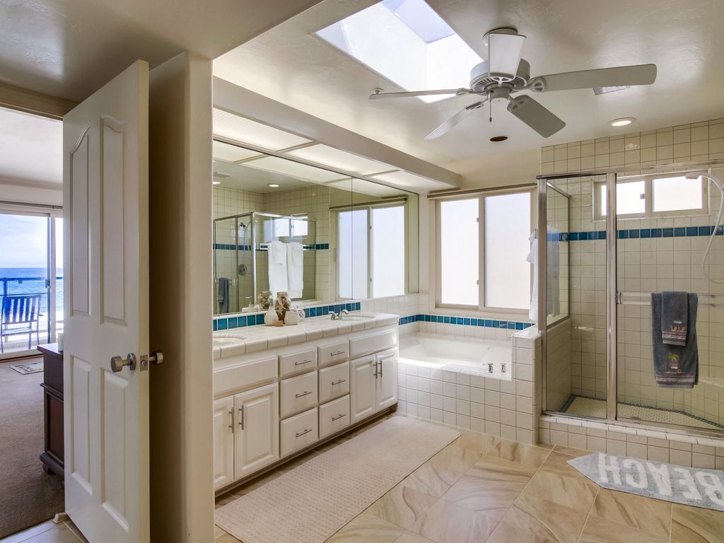 Une salle de bain moderne avec un grand miroir, une baignoire et une douche.