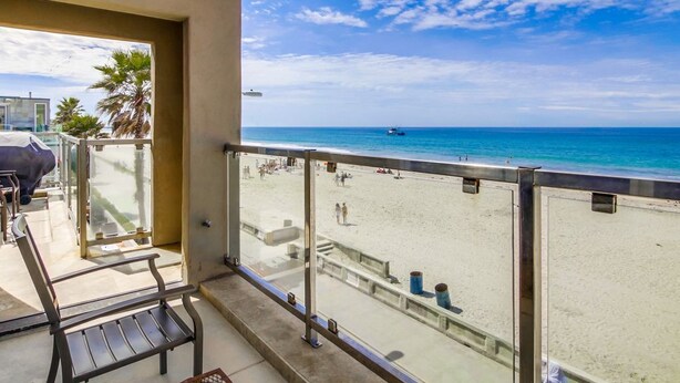 A balcony with a view of a beach and ocean. - Ocean Front House with Private Ground Level Patio & 2 Garages - Sleeps 10+ (San Diego)