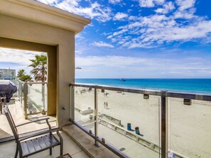 Ein Balkon mit Blick auf Strand und Meer.
