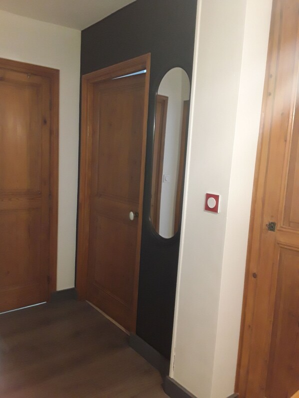 Un pasillo con puertas de madera, una pared blanca y una pared de acento negra.
