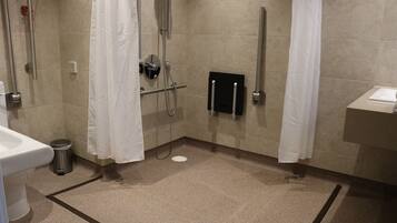 A bathroom with a shower, toilet, and sink.