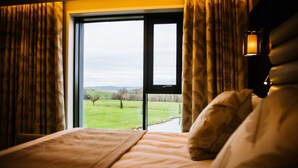 A bedroom with a large window, a bed, and a nightlight.