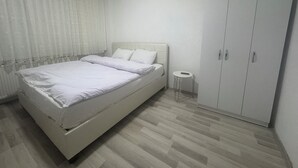 Una camera da letto con un letto, un tavolino e un armadio.
