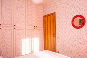 A bedroom with a bed, a wooden door, and a wall-mounted mirror. - M089 - Marcelli, three-room apartment with terrace 30 meters from the sea (Marcelli)
