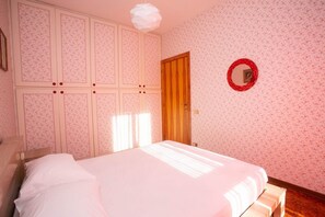 Une chambre à coucher avec un lit, une armoire et un miroir au mur.
