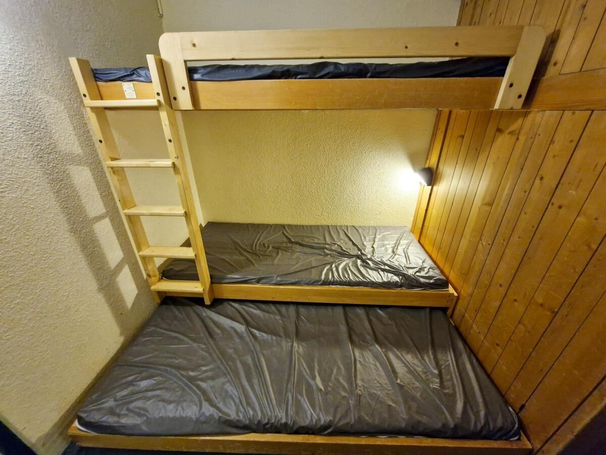 Un lit superposé avec une échelle et un matelas.