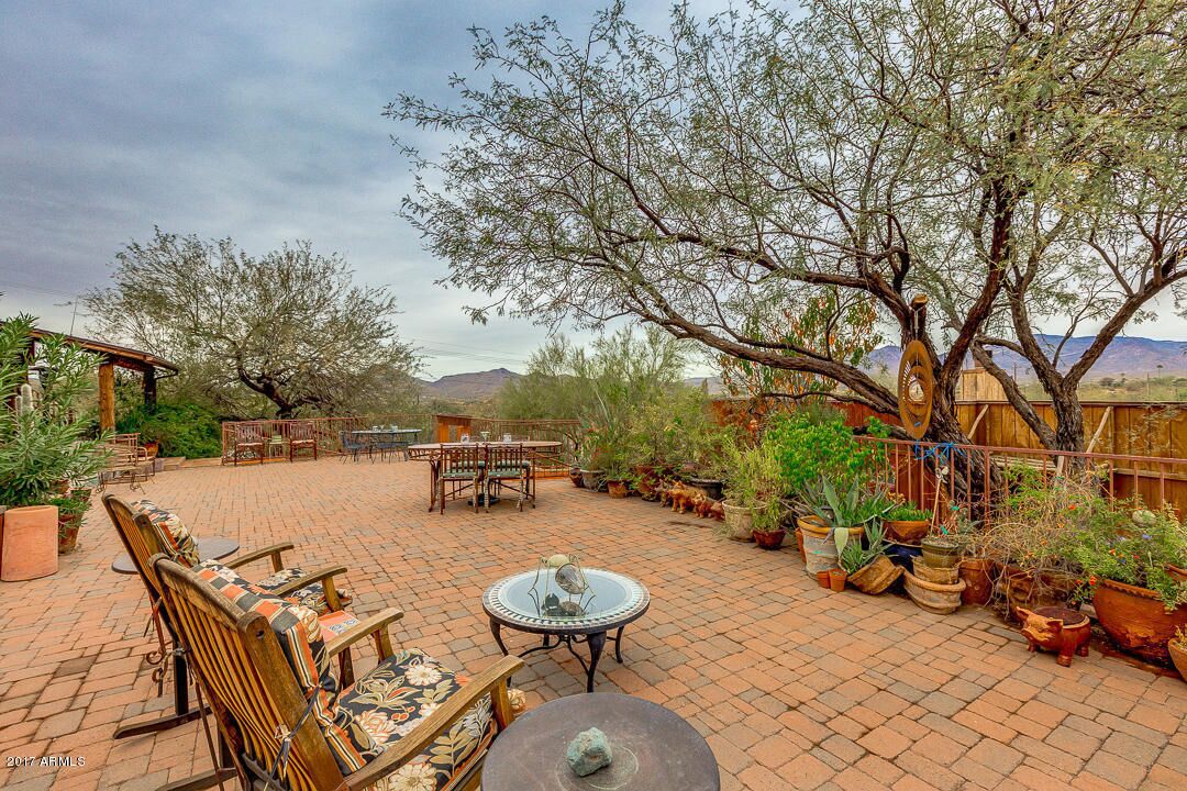 A patio area with outdoor furniture, potted plants, and a view of the desert landscape.