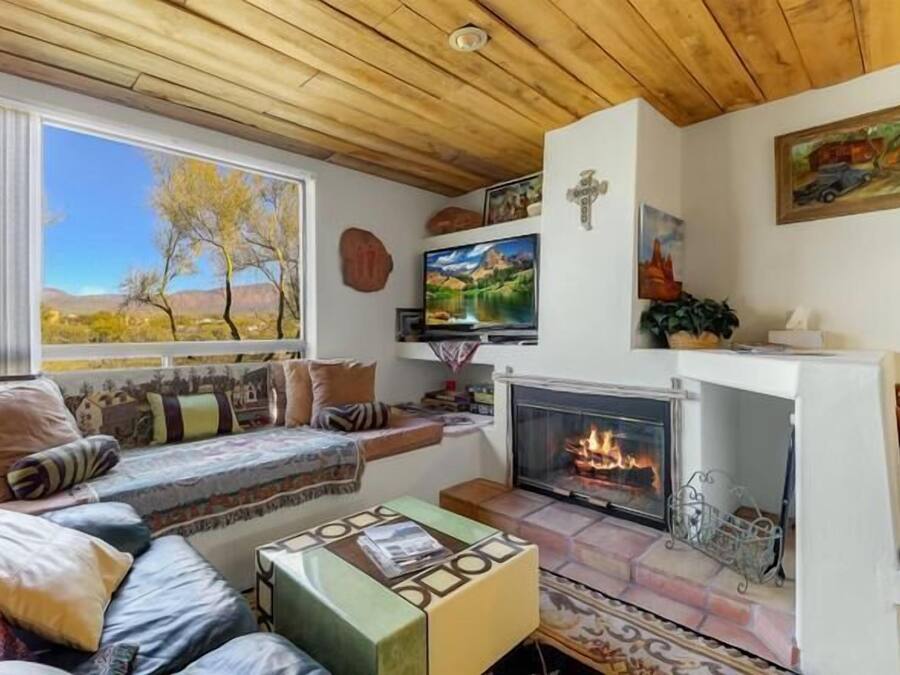 Una sala de estar acogedora con chimenea, asientos cómodos y una vista panorámica por la ventana.