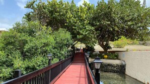 A red bridge with black railings, surrounded by lush greenery and a calm water body. - Waterfront Condominium Complex with Beautiful Sea Views 3 Bedroom 3 Bath  (Christiansted)