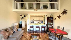 A living room with a sofa, coffee table, and dining area with chairs and a table. - Waterfront Condominium Complex with Beautiful Sea Views 3 Bedroom 3 Bath  (Christiansted)