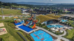 Ein Resort mit Wasserpark, mehreren Schwimmbecken und verschiedenen Sitzgelegenheiten im Freien.